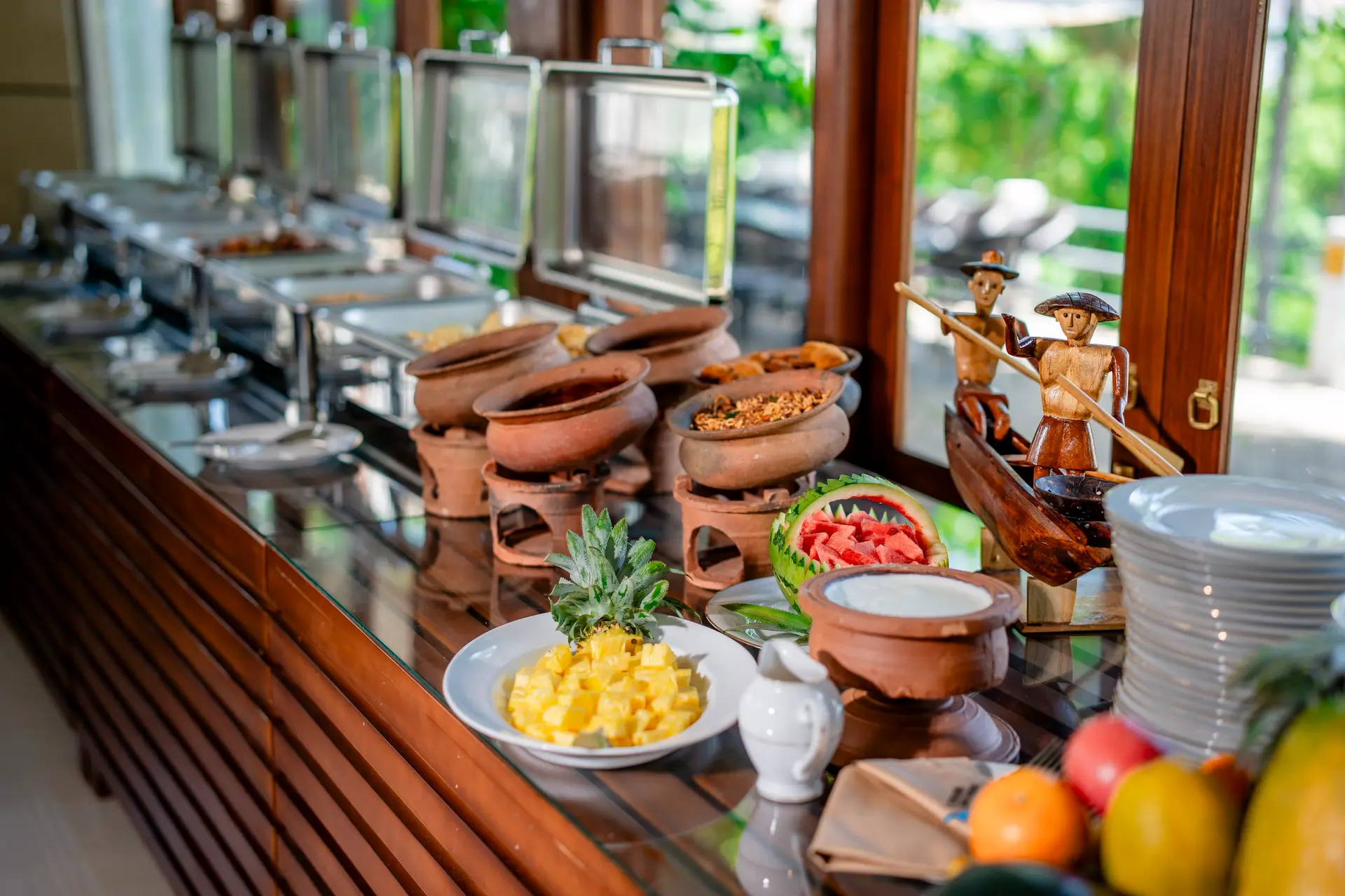 Buffet spread with carved fruit and wooden boat ornament