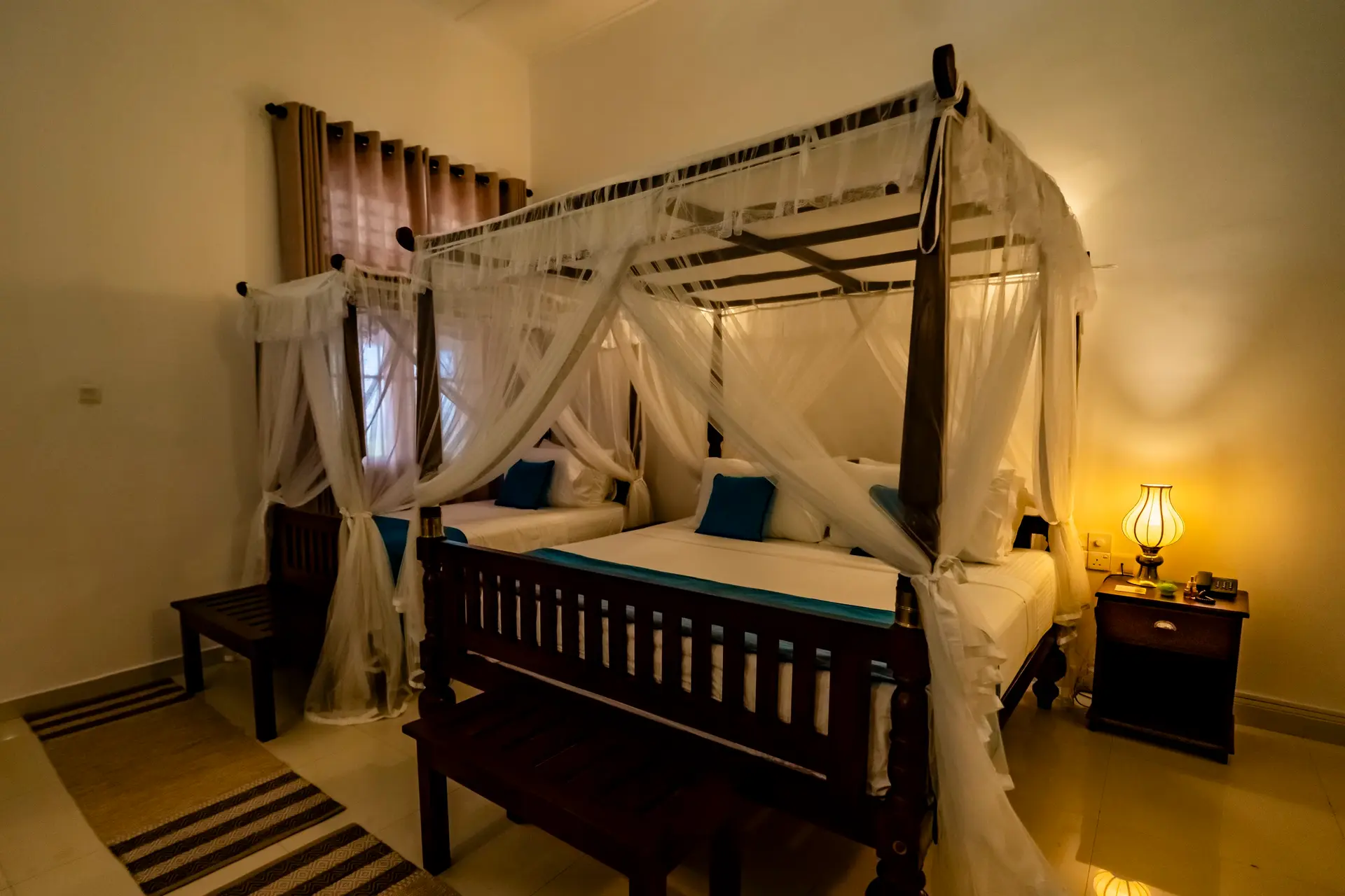 A room with twin canopy beds
