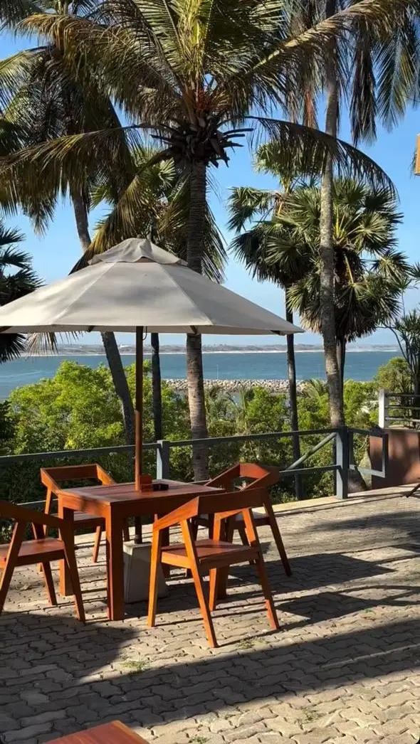 A terrace table under an umbrella, looking out over the harbour